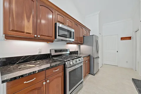 a kitchen with stainless steel appliances granite countertop a stove a sink and a microwave