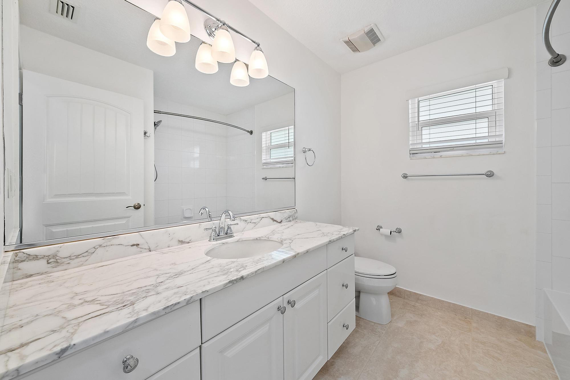 12 Bentwood Road Palm Beach Gardens, FL 33418 - Photo 22 of 40 a bathroom with a granite countertop sink mirror and toilet