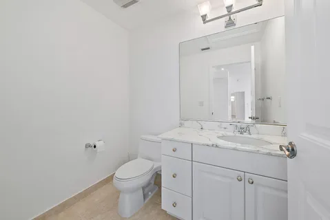 a bathroom with a granite countertop sink a toilet and a mirror