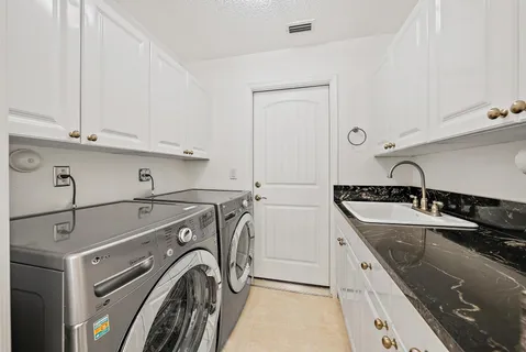 a view of a kitchen with sink washer and dryer