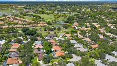 an aerial view of residential houses with outdoor space and trees