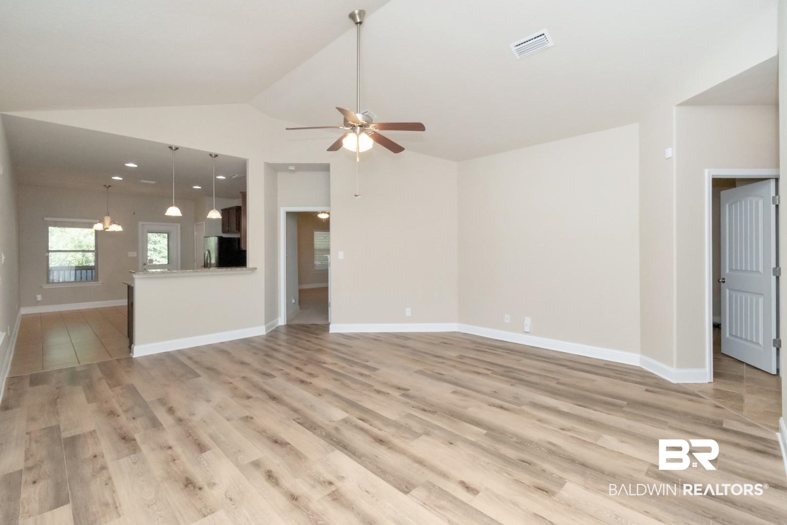 6144 Whitebark Drive Mobile, AL 36693 - Photo 2 of 33 Unfurnished living room featuring ceiling fan with notable chandelier, lofted ceiling, and light wood-type flooring