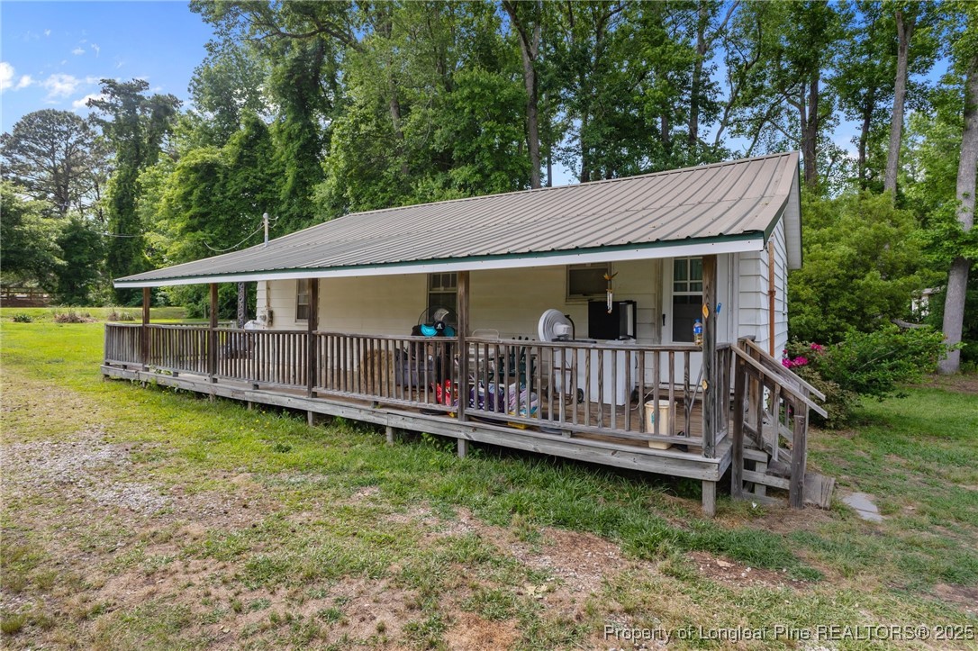 a view of a house with a backyard and deck