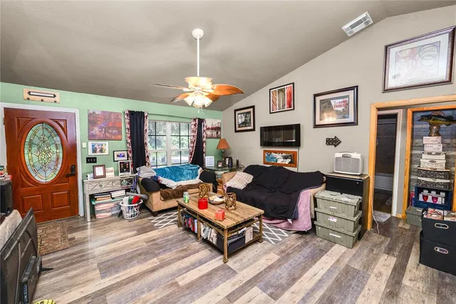 a living room with furniture a chandelier and a flat screen tv