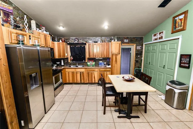 a kitchen with stainless steel appliances a table chairs and a refrigerator