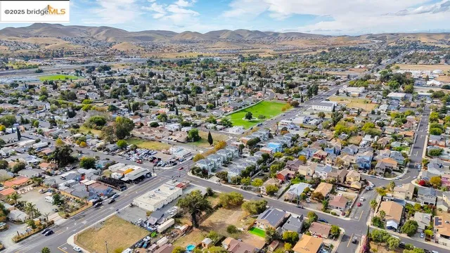 an aerial view of ocean and residential houses with outdoor space