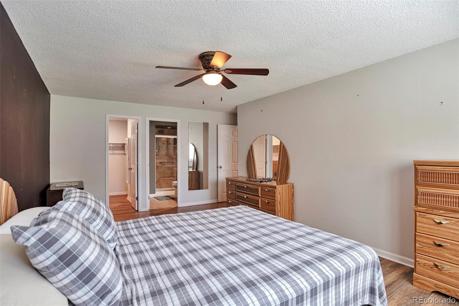 650 South Clinton Street, Unit 3A Denver, CO 80247 - Photo 13 of 25 a bedroom with a bed and dresser with mirror
