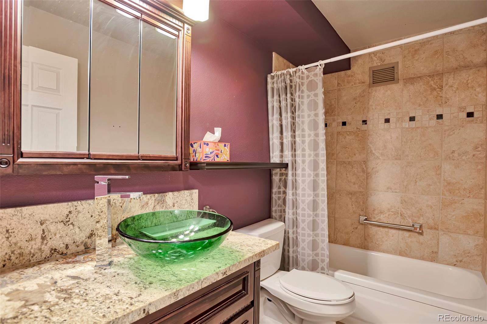 650 South Clinton Street, Unit 3A Denver, CO 80247 - Photo 16 of 25 a bathroom with a granite countertop bathtub sink vanity mirror and toilet
