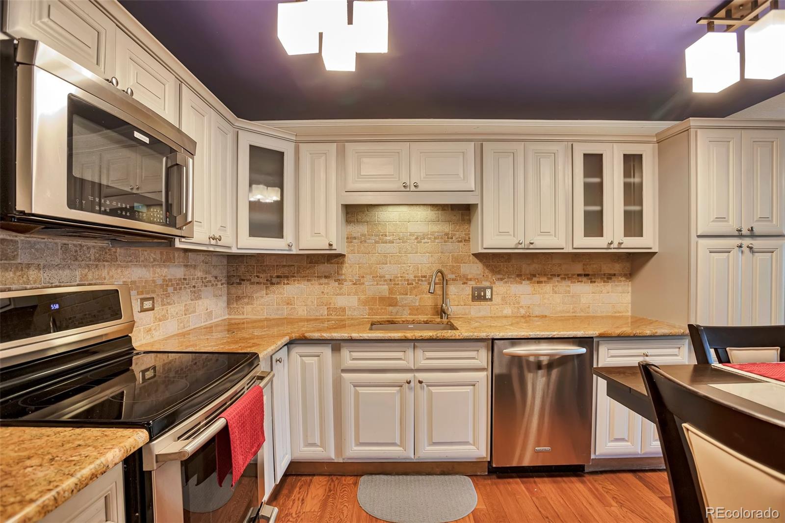 650 South Clinton Street, Unit 3A Denver, CO 80247 - Photo 5 of 25 a kitchen with stainless steel appliances granite countertop a stove a sink and a microwave