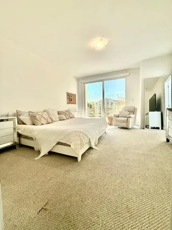 a bedroom with a bed and a large window