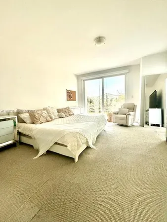 a spacious bedroom with a bed and glass walk in closet