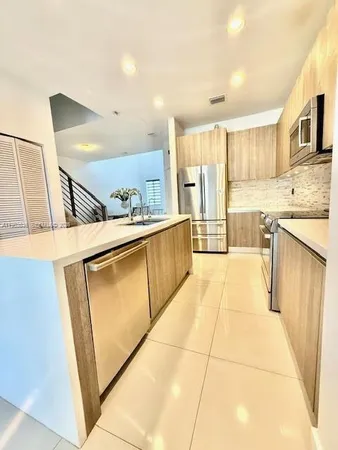 a kitchen with stainless steel appliances granite countertop a refrigerator and a stove top oven