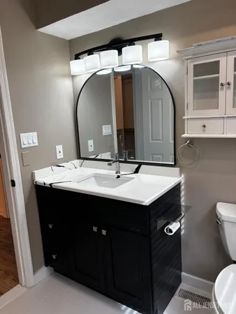 a bathroom with a sink vanity and toilet