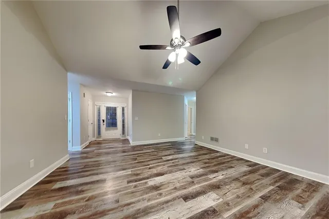 a view of an empty room and chandelier fan