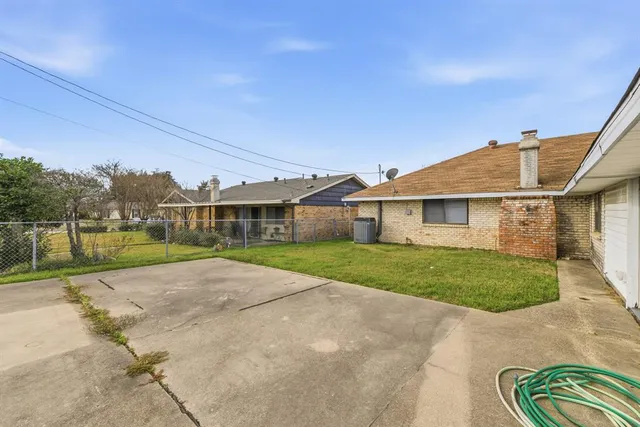 a view of a big house in front of a big yard with plants and large trees