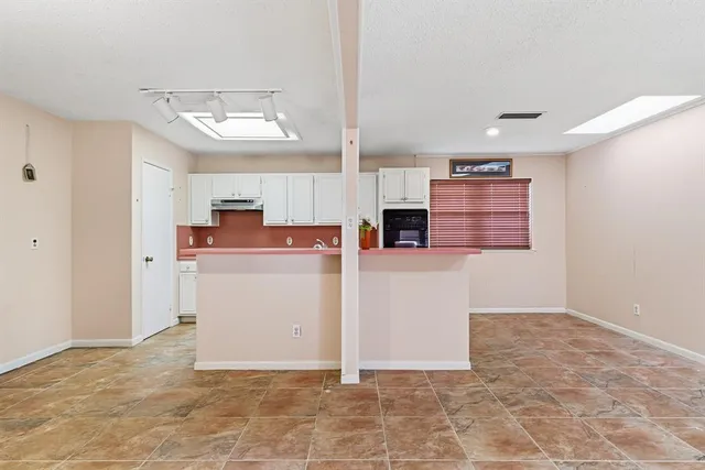 a view of kitchen with cabinets and refrigerator
