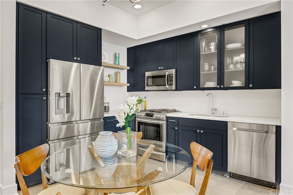 125 Hurlbut Street, Unit 101 Pasadena, CA 91105 - Photo 16 of 53 a kitchen with stainless steel appliances granite countertop a refrigerator a stove a sink a dining table and chairs