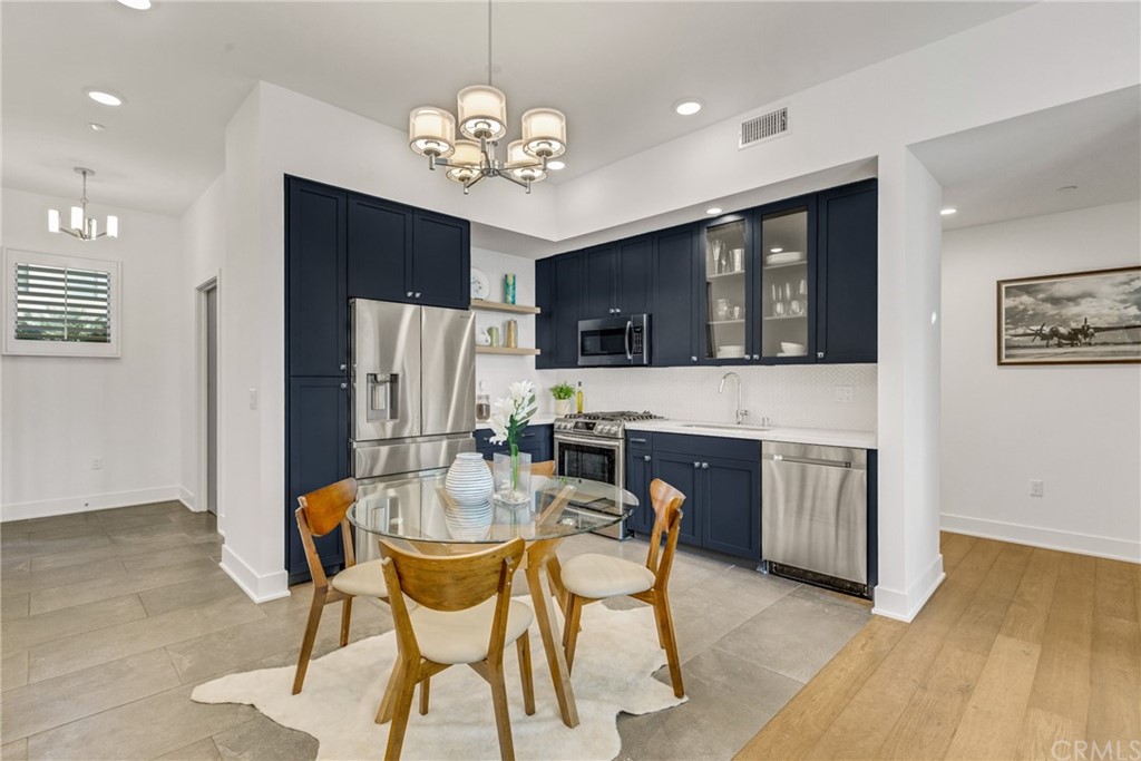 125 Hurlbut Street, Unit 101 Pasadena, CA 91105 - Photo 17 of 53 a view of a dining room with furniture a kitchen and chandelier