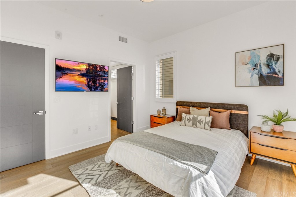 125 Hurlbut Street, Unit 101 Pasadena, CA 91105 - Photo 21 of 53 a bedroom with a bed and wooden floor