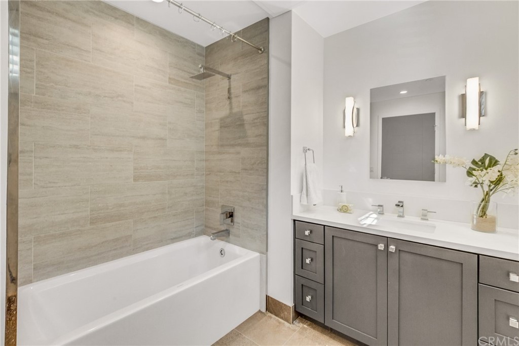 125 Hurlbut Street, Unit 101 Pasadena, CA 91105 - Photo 24 of 53 a bathroom with a tub a sink and mirror