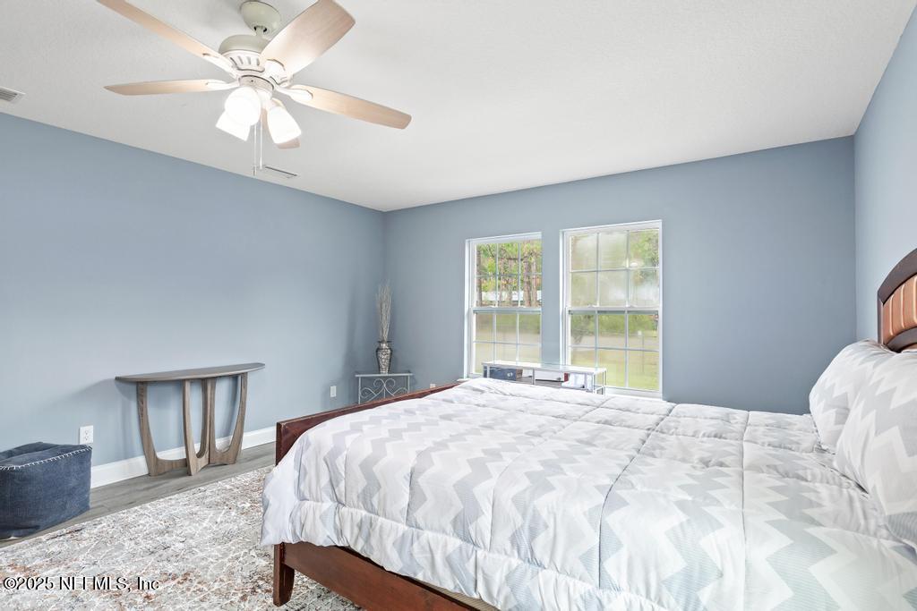 54174 Deerfield Country Club Road Callahan, FL 32011 - Photo 20 of 36 a bedroom with a large bed and a chandelier