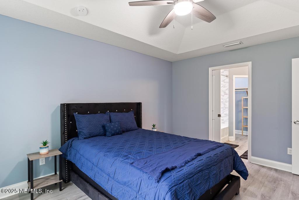 54174 Deerfield Country Club Road Callahan, FL 32011 - Photo 27 of 36 a bedroom with a bed and a chandelier