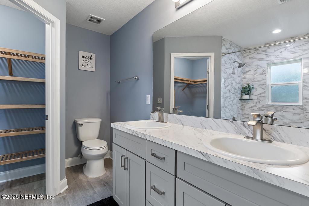 54174 Deerfield Country Club Road Callahan, FL 32011 - Photo 29 of 36 a bathroom with a granite countertop sink a toilet and a mirror