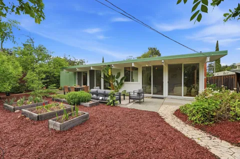 a view of a house with sitting area and garden