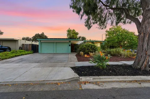 a front view of a house with a yard and potted plants