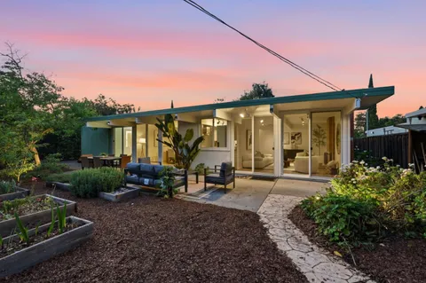 a front view of a house with garden and seating space