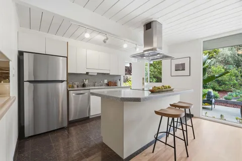 a kitchen with white cabinets and refrigerator