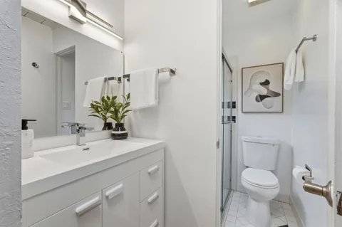 a bathroom with a sink a toilet and mirror