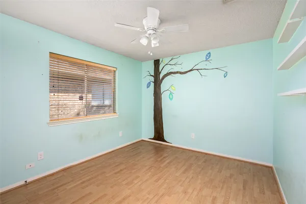 a view of a room with a window and a ceiling fan