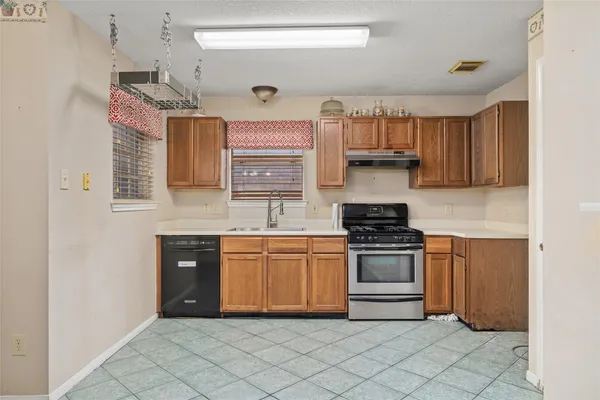 a kitchen with granite countertop a stove top oven cabinets and a refrigerator
