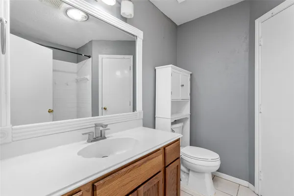 a bathroom with a sink toilet vanity and shower