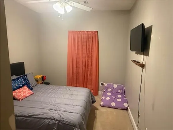 a bedroom with a bed and a flat tv screen