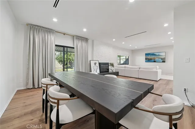 a room with stainless steel appliances furniture dining table and chairs