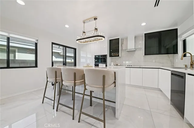 a kitchen with stainless steel appliances kitchen island granite countertop a table and chairs in it
