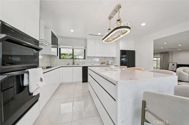 a large white kitchen with a stove a sink and dishwasher