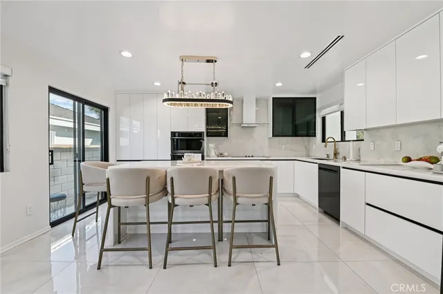 a kitchen with stainless steel appliances a sink a stove a table and chairs