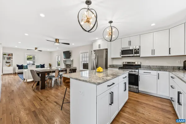 a kitchen with cabinets appliances and a clock