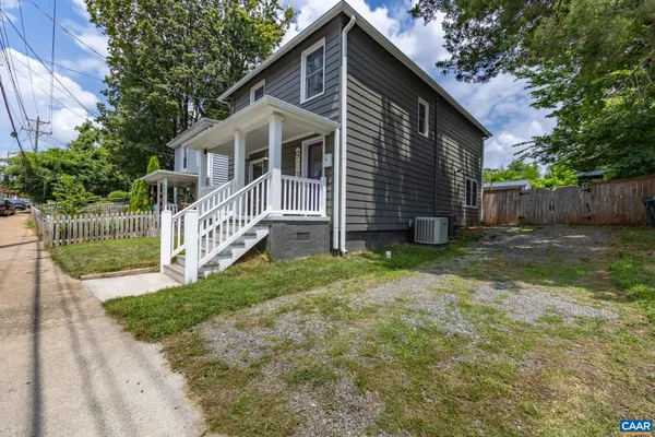 a view of a house with a yard and fence