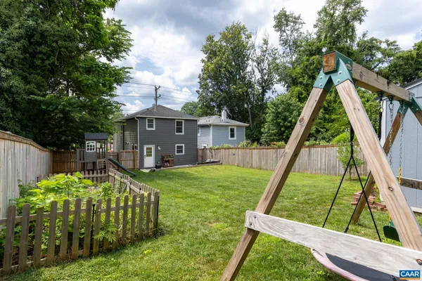 a view of house with backyard and a slide