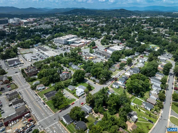 an aerial view of residential houses with outdoor space and trees