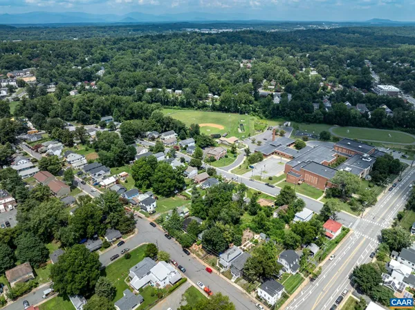 an aerial view of residential houses with outdoor space and trees