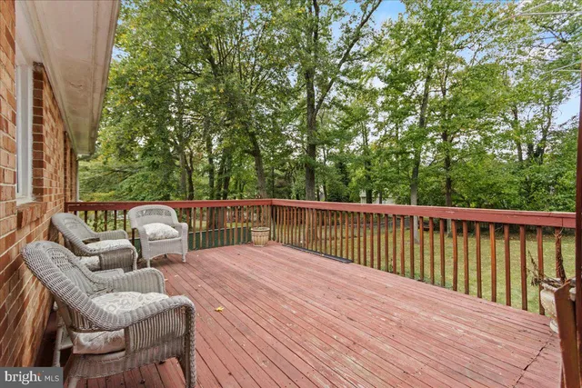 a balcony with wooden floor and outdoor seating