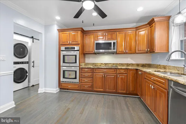 a kitchen with stainless steel appliances granite countertop a stove a sink and a microwave