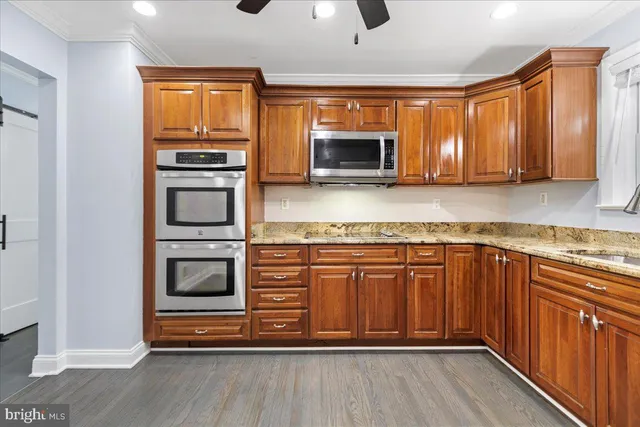 a kitchen with stainless steel appliances granite countertop a stove top oven microwave and refrigerator