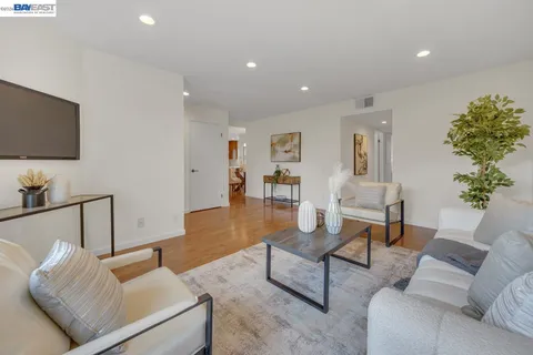 a view of a dining room with furniture a chandelier and wooden floor