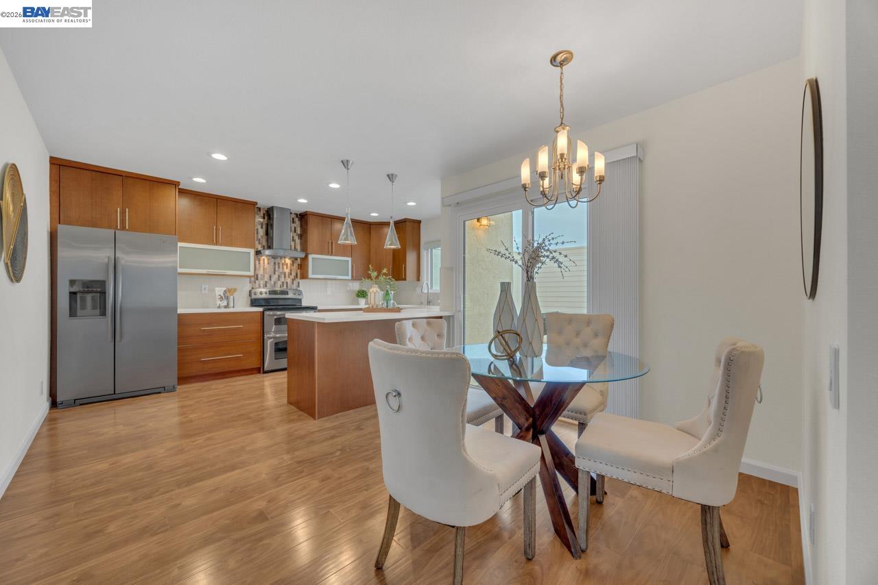 4034 Rennellwood Way Pleasanton, CA 94566 - Photo 21 of 42 a view of a dining room with furniture a chandelier and wooden floor